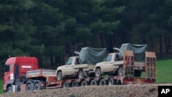A truck, part of a convoy, carrying military pickup trucks with machine guns attached is seen on the outskirts of the village of Sugedigi, Turkey, Jan. 21, 2018.