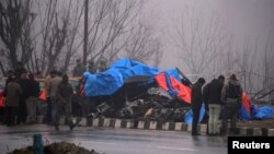Forensic officials inspect the wreckage of a bus after a suicide bomber rammed a car into the bus carrying Central Reserve Police Force (CRPF) personnel Thursday, in Lethpora in south Kashmir's Pulwama district, Feb. 15, 2019.