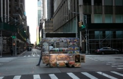 A food truck vendor pushes his cart down an empty street near Times Square in New York, on Sunday, March 15, 2020.