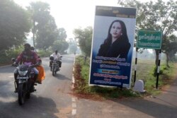 Orang-orang melintas di depan papan bergambar Kamala Harris, calon wakil presiden AS dari Partai Demokrat, di Desa Thulasendrapuram, selatan Chennai, negara bagian Tamil Nadu, Selasa, 3 November 2020.