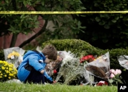 Dečak Gideon Marfi polaže cveće ispred sinagoge "Drvo života"