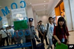 A group of former slave fishermen escorted by Myanmar police officers and IMO officials arrive at Myanmar’s international airport, Yangon, Saturday, May 9, 2015. They were the first Burmese men to return home following an Associated Press investigation.