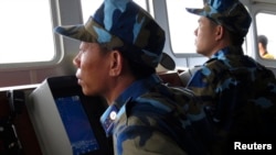 Crewmen aboard Vietnam coastguard ship 8003 look at a Chinese navy frigate on a screen, in disputed waters close to the Haiyang Shiyou 981, known in Vietnam as HD-981, oil rig in the South China Sea, July 15, 2014.