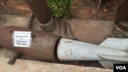 កាល​សំណល់​គ្រាប់​បែក​ដែល​ដាក់​តាំង​នៅ​ពី​មុខ​សារមន្ទី​មីន​កម្ពុជា​ សិ្ថត​ក្នុង​ឃុំ​ខ្នាសណ្តាយ​ ស្រុក​បន្ទាយស្រី​ ខេត្ត​សៀមរាប​ កាល​ពី​ថ្ងៃ​ទី៩ ខែមករា​ ឆ្នាំ២០១៦។​ (ហ៊ុល រស្មី​/VOA)