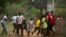 A crowd runs for cover as African Union (AU) peacekeeping soldiers fire warning shots to disperse a crowd near the district of Miskine in Bangui, Feb. 7, 2014. 