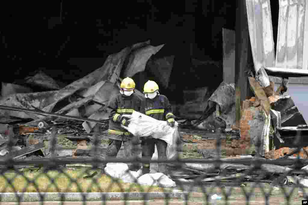 Firefighters prepare bags that appear to contain the remains of victims from a poultry processing plant that was engulfed by a fire in Jilin province, China, June 3, 2013.