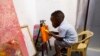 گھانا کا ننھا ایس لیئم نینا سیم اینکرہ، جنہوں نے کم عمر ترین مرد آرٹسٹ کا عالمی ریکارڈ قائم کیا ہے، اپنے گھر میں بنے آرٹ کارنر میں پینٹنگ کرتے ہوئے، فوٹو اے پی 27 مئی 2024