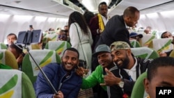Passengers pose for a selfie picture inside an Ethiopian Airlines flight which departed from the Bole International Airport in Addis Ababa, Ethiopia, to Eritrea's capital Asmara on July 18, 2018. 
