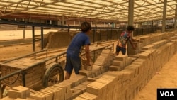 កុមារអាយុក្រោម១៥ឆ្នាំ កំពុងជញ្ជូនឥដ្ឋដាក់រទេះ ក្នុងបរិវេណសិប្បកម្មឡឥដ្ឋ នៅឃុំព្រែកអញ្ចាញ ស្រុកមុខកំពូល ខេត្តកណ្តាល កាលពីថ្ងៃទី១៥ ខែតុលា ឆ្នាំ២០២១។ (កាន់ វិច្ឆិកា/វីអូអេ)