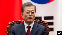 South Korean President Moon Jae-In sits next to Chinese President Xi Jinping (not seen) during a signing ceremony at the Great Hall of the People in Beijing, Dec. 14, 2017. 