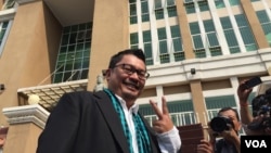 លោក​ អ៊ូ វីរៈ ​អ្នក​វិភាគ​នយោបាយ ឈរ​នៅ​ខាង​មុខ​តុលាការ​ក្រុង​ភ្នំពេញ មុន​ពេល​លោក​ចូល​​ទៅ​បំភ្លឺ​មុខ​ព្រះរាជ​អាជ្ញា ទាក់​ទិន​បណ្តឹង​បរិហាកេរ្តិ៍​ប្រឆាំង​រូបលោក។ (ហ៊ុល រស្មី/VOA)