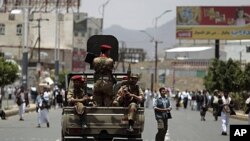 Army soldiers stand guard in a truck as anti-government protesters take part in a demonstration demanding the ouster of Yemen's President Ali Abdullah Saleh in Sana'a, June 3, 2011