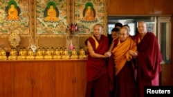 На тибетскиот духовен водач Далај Лама монасите му помагаат да влезе во салата во неговата хималајска резиденција во Дарамсала, Индија, на 20 декември 2024 година.