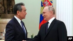 Rais wa Russsia Vladimir Putin akisalimiana na Mkuu wa Sera ya Kigeni wa Chama cha Kikomunisti cha China Wang Yi wakati wa mkutano wao kwenye Ikulu ya Kremlin mjini Moscow, Jumatano, Februari 22, 2023.
AP
