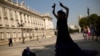 ARCHIVO - Una bailaora de flamenco, con su tradicional vestido, baila frente al Palacio Real en Madrid.
