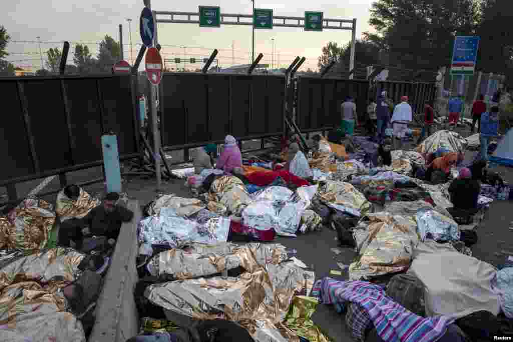 Migrants sleep in front of a barrier at the border with Hungary near the village of Horgos, Serbia.