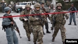 FILE - NATO soldiers leave the site of a car bomb blast in Kabul, Afghanistan, Aug. 22, 2015. 