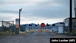 FILE - In this July 22, 2019 file photo, signs warn about trespassing at an entrance to the Nevada Test and Training Range near Area 51 outside of Rachel, Nevada.