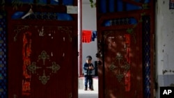 新疆和田的一名維吾爾小孩獨自在家中院子裡玩耍（美聯社2018年9月20日）