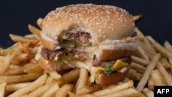 FILE - A partially eaten hamburger is seen atop a portion of French fries.