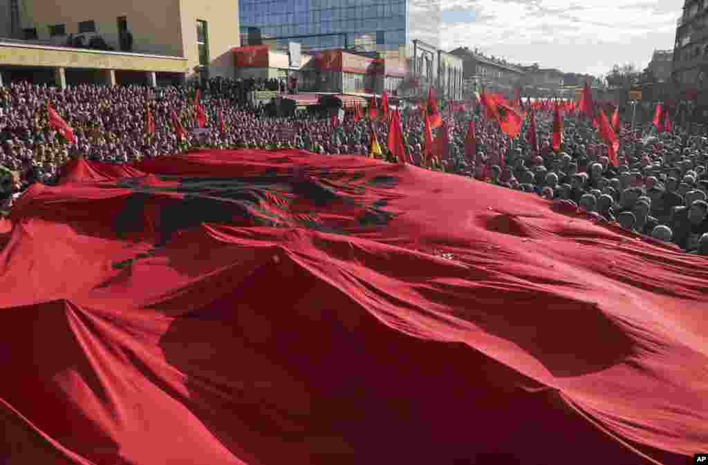 A massive Albanian flag is carried on top of tens of thousands of Kosovo opposition supporters during anti-government rally in Kosovo's capital Pristina.