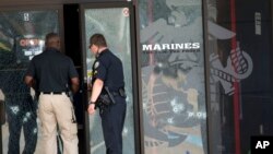 Police officers enter the Armed Forces Career Center through a bullet-riddled door after a gunman opened fire on the building in Chattanooga, Tennessee, July 16, 2015.
