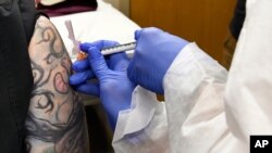  En esta foto del 27 de julio del 2020, la enfermera Kathe Olsmtead inyecta a un voluntario durante los estudios de una vacuna para el coronavirus en Binghamton, Nueva York. 