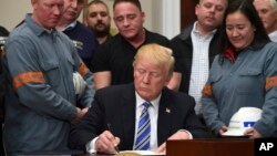 President Donald Trump signs a proclamation on steel imports during an event in the Roosevelt Room of the White House in Washington, March 8, 2018. He also signed one for aluminum.