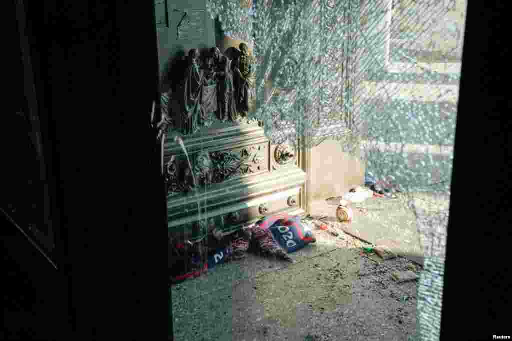 Escombros vistos a través de una ventana rota del Capitolio.