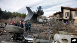 Waokoaji wakiwa katika eneo la ajali na vyombo vya usalama vikifanya kazi pamoja baada ya ndege hiyo ya mizigo aina ya Boeing 707 kuanguka uwanja wa ndege wa Fath magharibi mwa Tehran, Iran, Jumatatu, Jan. 14, 2019.