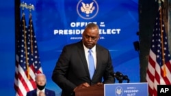 ARCHIVO - El entonces presidente electo Joe Biden observa cómo el general retirado del ejército Lloyd Austin, su elección para secretario de Defensa, abandona el podio después de hablar en el teatro The Queen en Wilmington, Delaware, el 9 de diciembre de 2020.