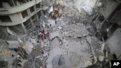 ពលរដ្ឋប៉ាឡេស្ទីន​ពិនិត្យមើលសំណង់អគារដែលត្រូវបានបំផ្លាញ ក្រោយការវាយប្រហារតាមអាកាស​របស់អ៊ីស្រាអែលជាការសងសឹកនឹងការវាយឆ្មក់របស់​ក្រុម​សកម្មប្រយុទ្ធហាម៉ាស់ នៅទីក្រុង Khan Younis នៃតំបន់ហ្គាហ្សាស្ទ្រីប ថ្ងៃទី ១០ ខែតុលា ឆ្នាំ ២០២៣។ 