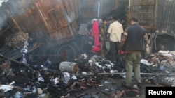 People salvage goods from an aid convoy that was damaged during an airstrike in the rebel held area of al-Sakhour district of Aleppo, Syria, June 4, 2016.