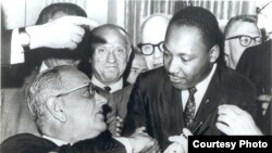 Martin Lyuter King (o'ngda) Saylov huquqlari to'g'risidagi qonunning qabul qilinishi munosabati bilan AQSh prezidenti Lindon Jonson bilan qo'l siqib ko'rishmoqda, 1965-yil, 6-avgust.