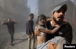 Palestinac nosi dete sa mesta izraelskog vazdušnog udara u Kan Junisu, na jugu Pojasa Gaze, 26. oktobra 2023.