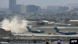 U.S. soldiers stand on the tarmac as a U.S. Air Force aircraft prepares for take off from the airport in Kabul on August 30, 2021.