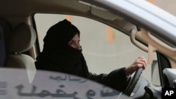Aziza Yousef drives a car on a highway in Riyadh, Saudi Arabia, as part of a campaign to defy Saudi Arabia's ban on women driving, March 29, 2014. (AP Photo/Hasan Jamali, File)