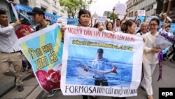 FILE - Vietnamese protesters hold a banner reading 'We love the sea, fish and shrimp. Formosa get out' during a rally denouncing recent mass fish deaths in Vietnam's central province, in Hanoi, Vietnam, 01 May 2016. 