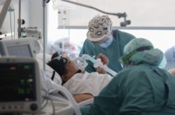 Hospital staff treat a patient suffering from COVID-19 at Hospital del Mar, where an additional ward has been opened to deal with an increase in coronavirus patients in Barcelona, Spain, July 15, 2021.
