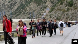 大多数是俄罗斯人2022年9月28日越过格鲁吉亚和俄罗斯之间的边界后行走。他们许多人是为了逃避俄罗斯的征兵令。（美联社照片）