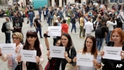 Bosnian journalists hold up banners reading "Journalism is not a crime" and "Stop violence against journalists," in downtown Sarajevo to protest the beating of a journalist in Banja Luka, the main city in the Serb-run part of Bosnia, Aug. 28, 2018.