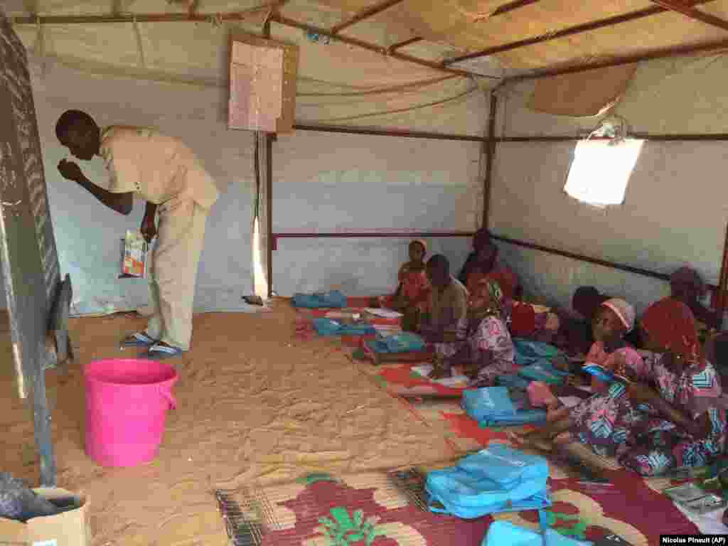 Thanks to supplies provided by UNICEF, school children at the Ngourtoua camp listen to their teacher, in Diffa, March 1, 2016. (N. Pinault/VOA)