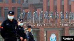 FILE - Security personnel keep watch outside the Wuhan Institute of Virology during the visit by the World Health Organization (WHO) team tasked with investigating the origins of the coronavirus disease, in Wuhan, China, Feb. 3, 2021.