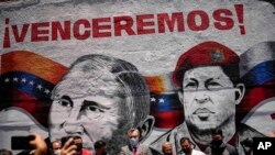 Посол Росії у Венесуелі Сергій Мелік Багдасаров біля муралу з зображенням президента РФ Володимира Путіна та покійного президента Венесуели Уґо Чавеса та написом "Переможемо!" у столиці Венесуели Каракасі, 2 квітня 2022 р. (AP Photo/Matias Delacroix)