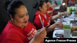 This photo was taken and released by Matangi Tonga on Oct. 30, 2021, shows a Tongan nurse preparing to vaccinate people against COVID-19 inside Queen Salote Memorial Hall in Nuku'alofa. (Photo by Eleanor Gee)