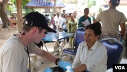 មន្ត្រី​កងទ័ពអាកាសសហរដ្ឋអាមេរិកម្នាក់ពិនិត្យសម្ពាធឈាមស្រ្តីមួយរូប នៅស្រុកកំពង់ត្រាច ខេត្តកំពត កាលពីថ្ងៃពុធ ទី១៥ ខែមិថុនា ឆ្នាំ២០១៦។