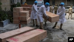 Vojnici iz tima za vanredne situacije prenose prazne kovčege za sahranu žrtava Kovida 19, ispred vladine bolnice u državi Džamu (Foto AP /Čani Anand)