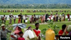 FILE - Rohingya refugees, who crossed the border from Myanmar, walk toward refugee camps, in Palang Khali, near Cox's Bazar, Bangladesh, Oct. 19, 2017.