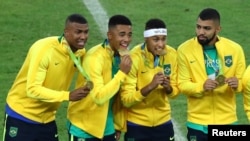 Neymar, second from right, and his Brazil teammates pose with their gold medals after defeating Germany to win the Olympic soccer final in Rio de Janeiro, Brazil, Aug. 20, 2016.