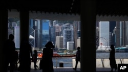 People walk at the waterfront of Hong Kong's Victoria Harbor, June 20, 2020.